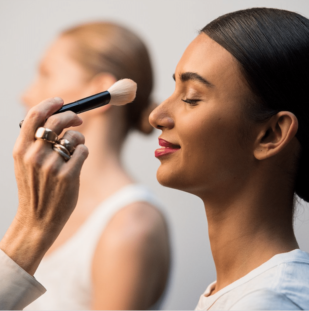 makeup application backstage of runway