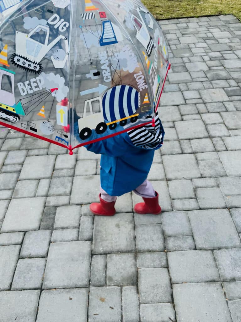 little boy with truck umbrella and red hunter boots